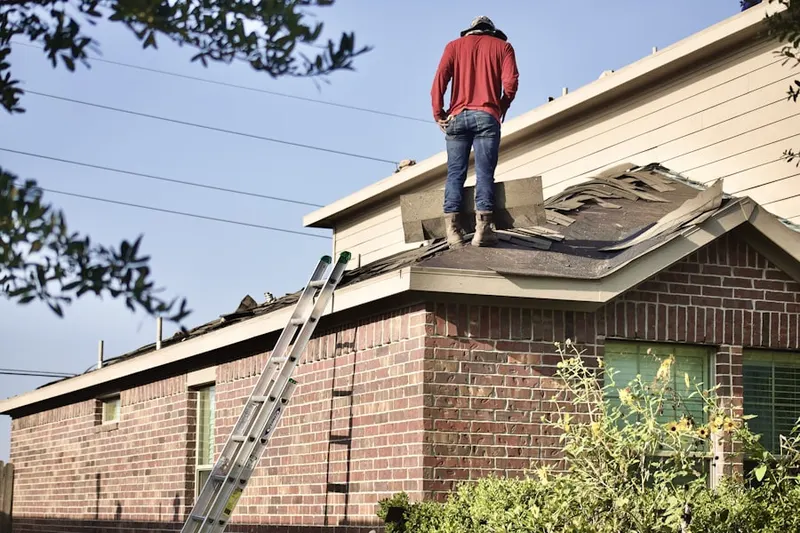 Professional roofer working on a residential roof in Genoa